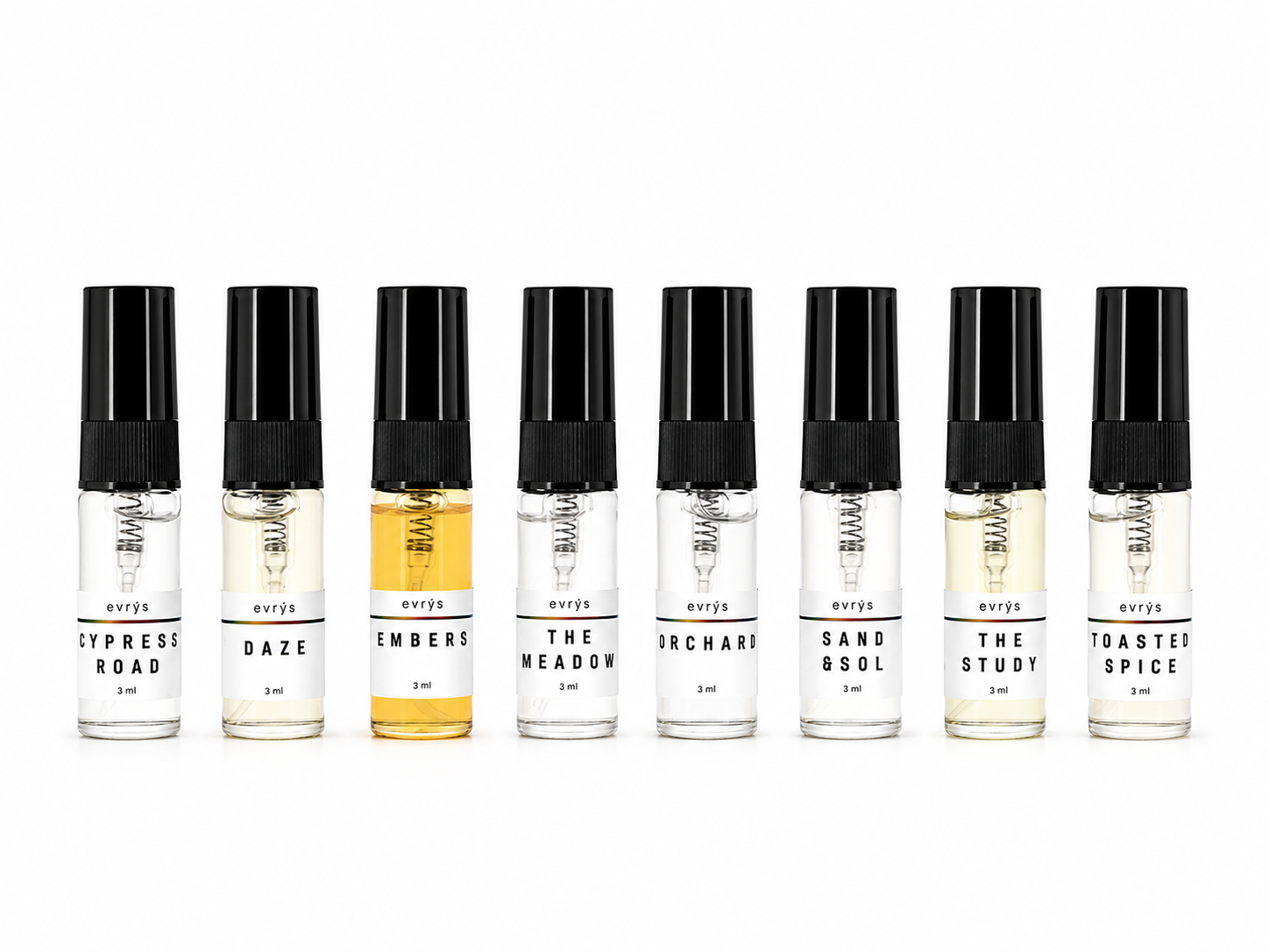 Set of eight small perfume bottles with black caps on a white background