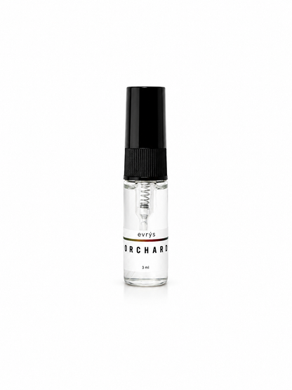 Small fragrance bottle with an evrys Orchard label and a black cap on a white background