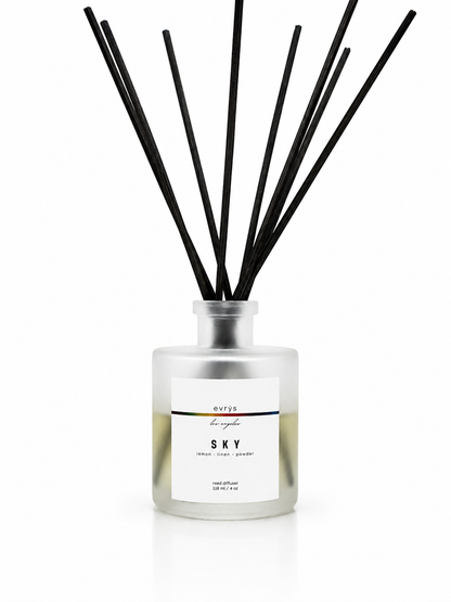 Sky diffuser with black reeds and a white label on a white background