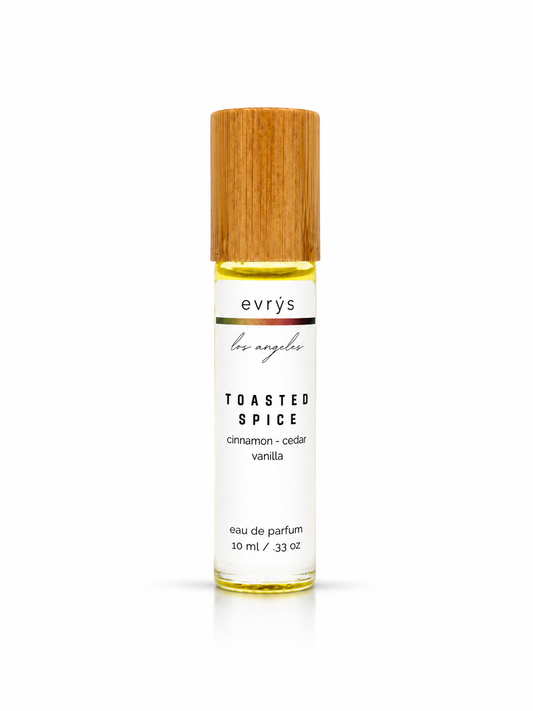 Evrys Toasted Spice oil roller parfum bottle with a bamboo cap on a white background